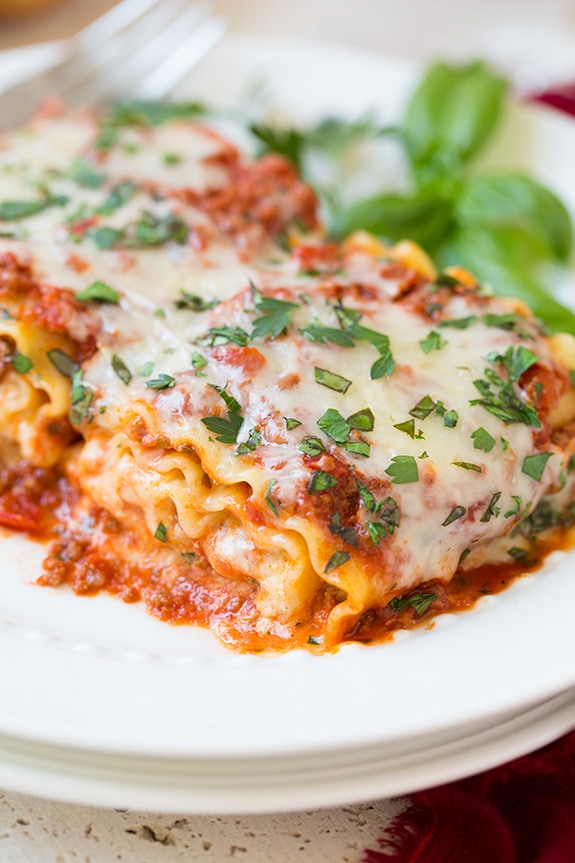 Lasagna Roll Ups on a white plate topped with basil