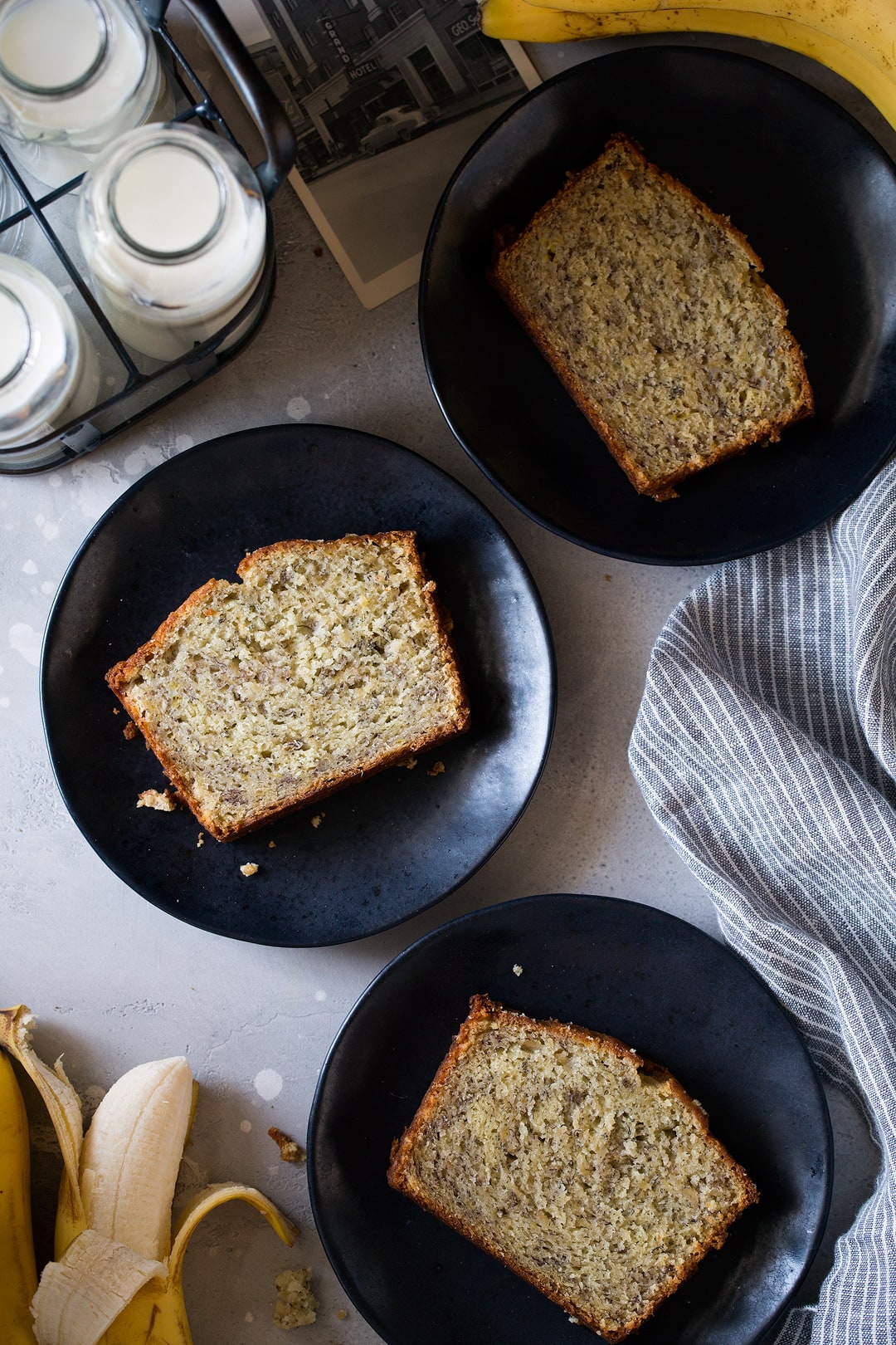 This is the best banana bread recipe! Quick and easy to make and no mixer is required. It's perfectly moist and amazingly tender and it's brimming with banana flavor. Simply put, everyone will have a hard time stopping at just one slice! #cookingclassy #banana #bread #bananabread three slices of homemade banana bread on three black plates