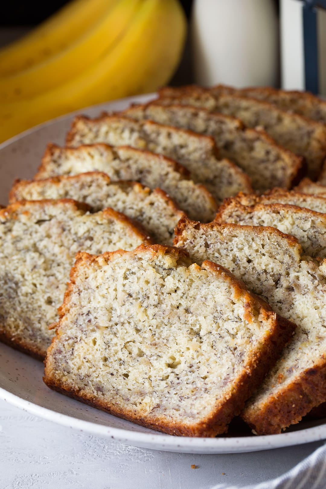 This is the best banana bread recipe! Quick and easy to make and no mixer is required. It's perfectly moist and amazingly tender and it's brimming with banana flavor. Simply put, everyone will have a hard time stopping at just one slice! #cookingclassy #banana #bread #bananabread homemade banana bread cut into slices on a large plate