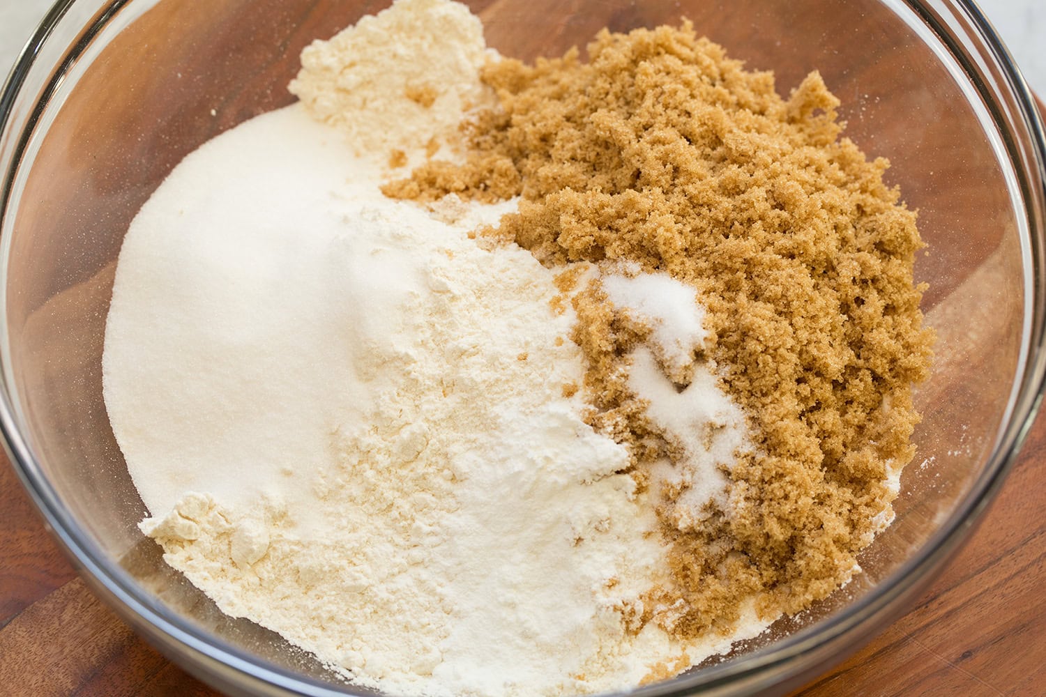 Apple Pie Bars Brown sugar, white sugar, salt, baking powder and flour added to a glass mixing bowl.