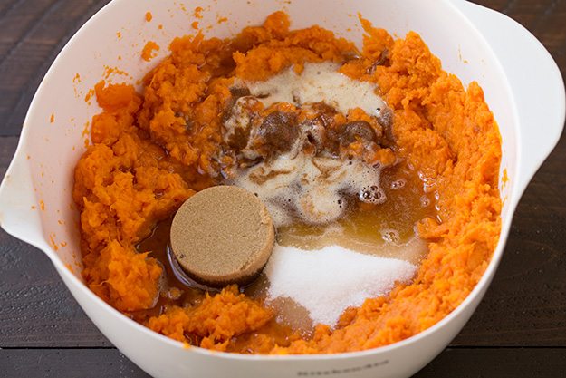 Adding sugars, salt and melted browned butter to sweet potatoes in mixing bowl.