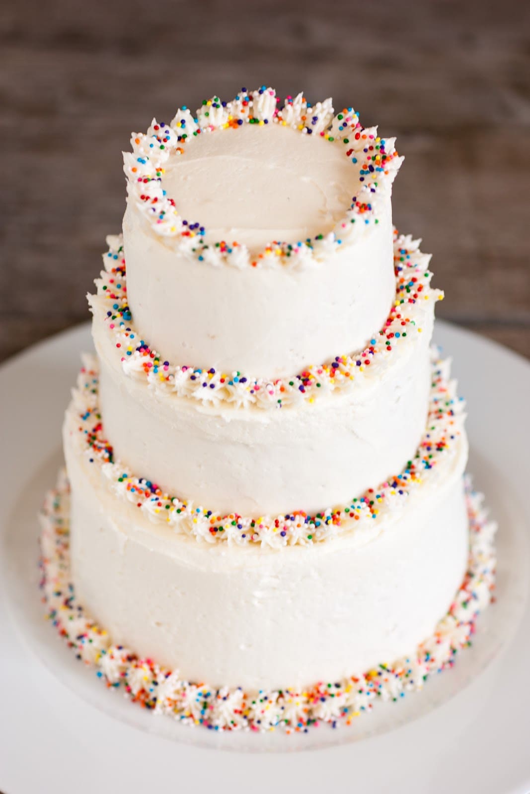 three tiered cake covered in homemade buttercream frosting