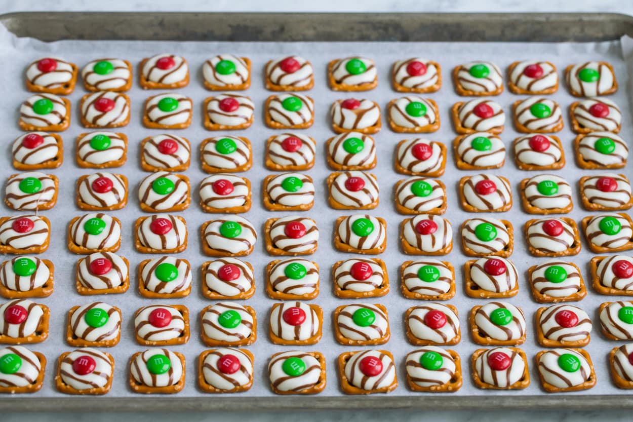 Pretzel M&M Hugs Adding M&M chocolate over melted hugs in center.