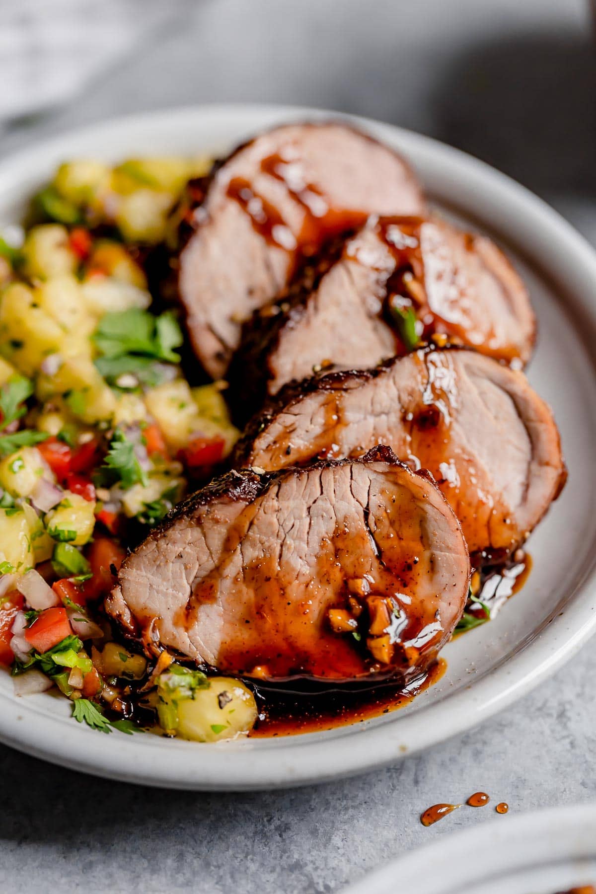 Island Pork Tenderloin on a platter with a side of pineapple salsa