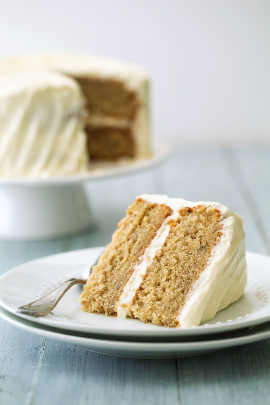 slice of Banana Cake sitting in front of cake on a cake stand