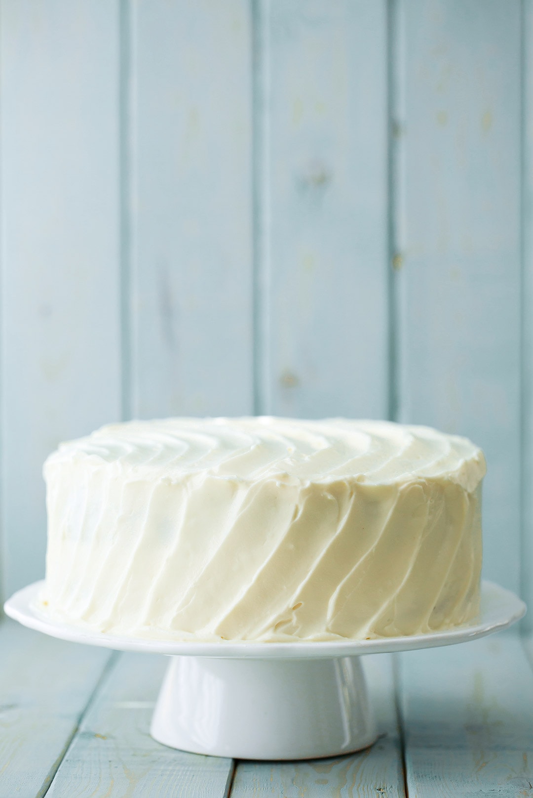 Banana Cake with cream cheese frosting on a white cake stand