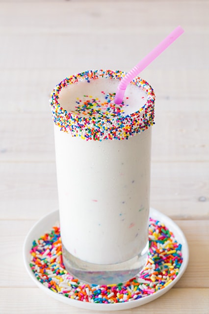 birthday cake milkshake garnished with sprinkles and a straw