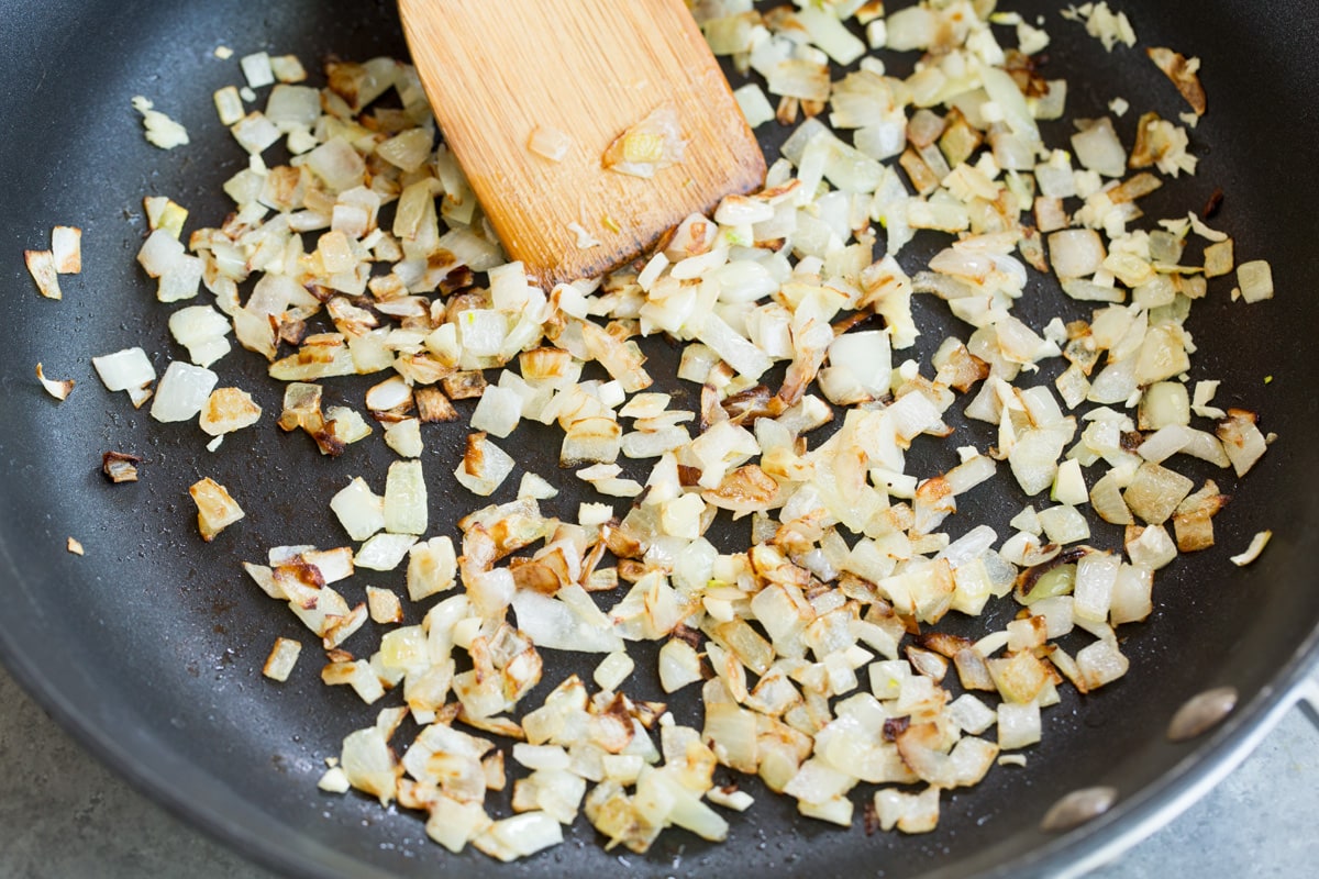 Sautéing onion in skillet to make sweet potato tacos.