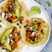 Three sweet potato and black bean tacos on white plate.