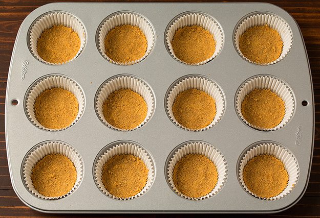 Mini Pumpkin Cheesecakes Graham cracker crusts in cupcake pan for mini pumkpin cheesecakes.