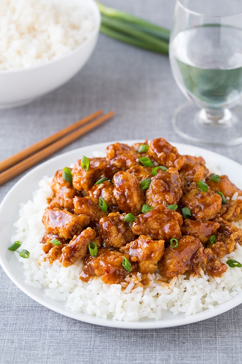 General Tso's Chicken on top of white rice on dinner plate