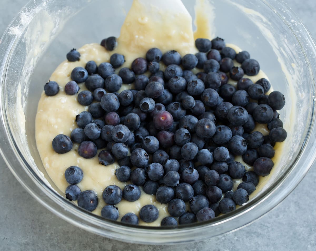 Folding blueberries into muffin batter.