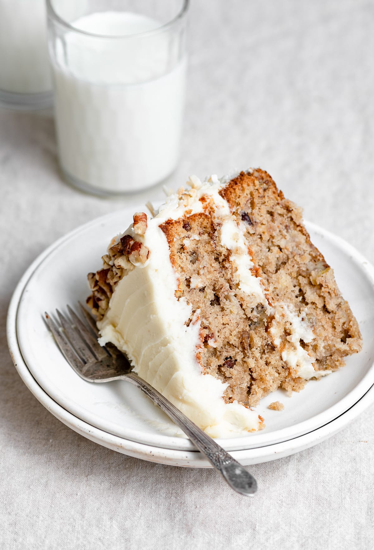 Single slice of homemade hummingbird cake on a white dessert plate.