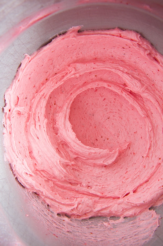 These Strawberry Cupcakes are made with chunks of fresh strawberries in the cake batter and are topped with a luscious pink Strawberry Buttercream Frosting. Bursting with flavor, these cupcakes would go down a treat at any celebration! #cookingclassy #cupcakes #strawberry #buttercream #cakes Strawberry Buttercream Frosting in a bowl