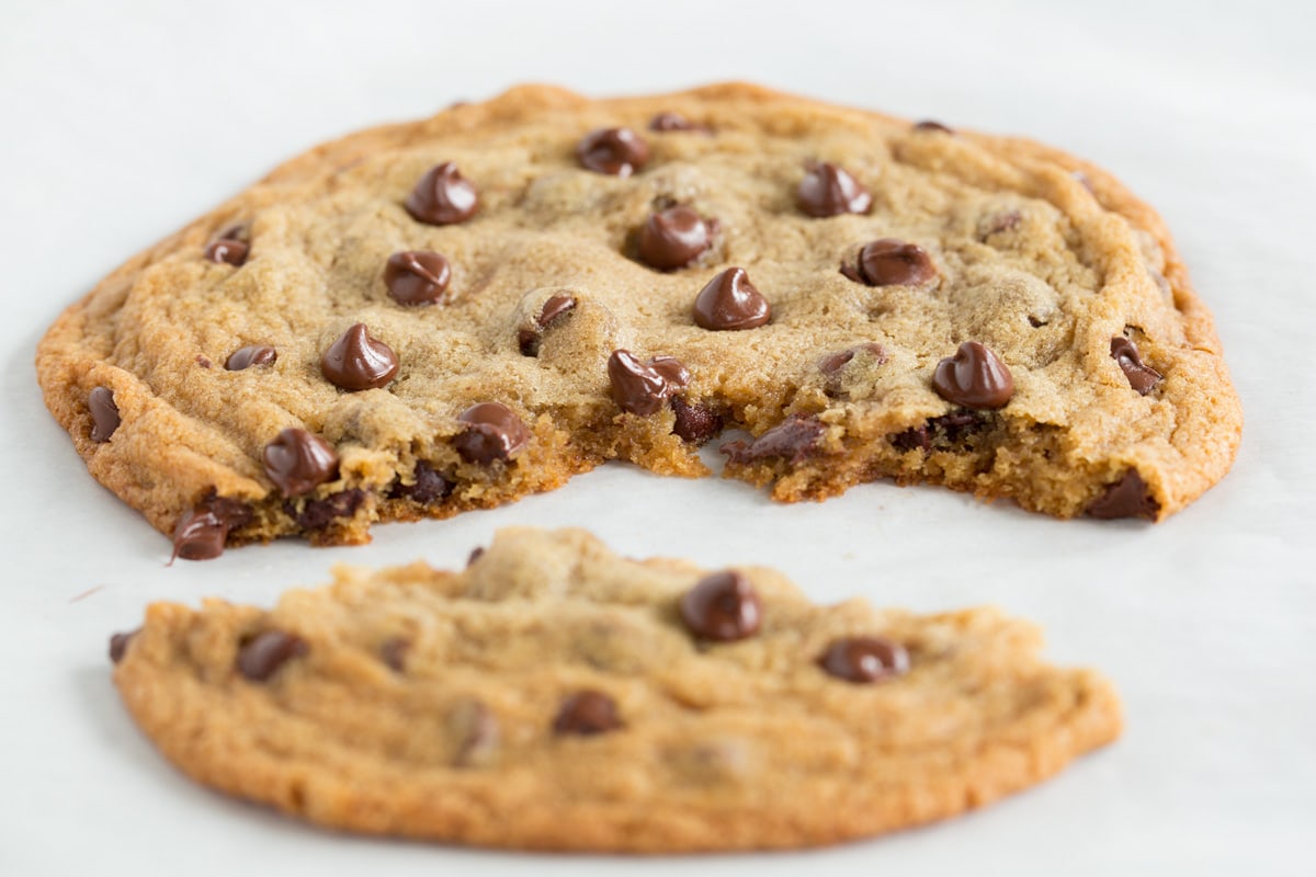Chocolate chip cookie with a portion broken off to show texture of interior of cookie.