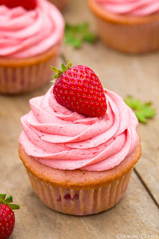 These Strawberry Cupcakes are made with chunks of fresh strawberries in the cake batter and are topped with a luscious pink Strawberry Buttercream Frosting. Bursting with flavor, these cupcakes would go down a treat at any celebration! #cookingclassy #cupcakes #strawberry #buttercream #cakes A close up of Strawberry Cupcakes with Strawberry Buttercream Frosting