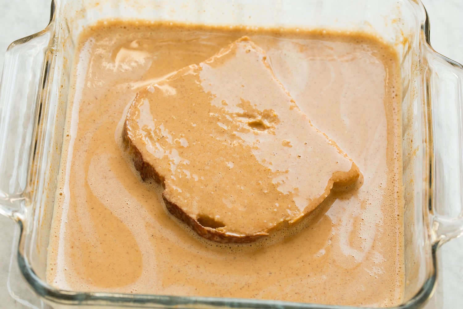 French bread shown dipped in pumpkin custard mixture on second side.
