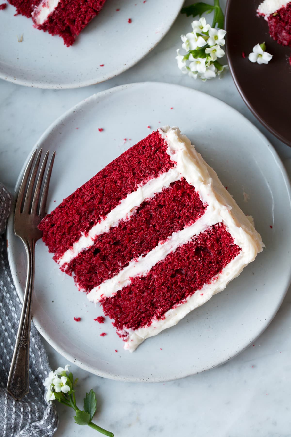 Overhead image of slice of Red Velvet Cake on a light grey serving plate.