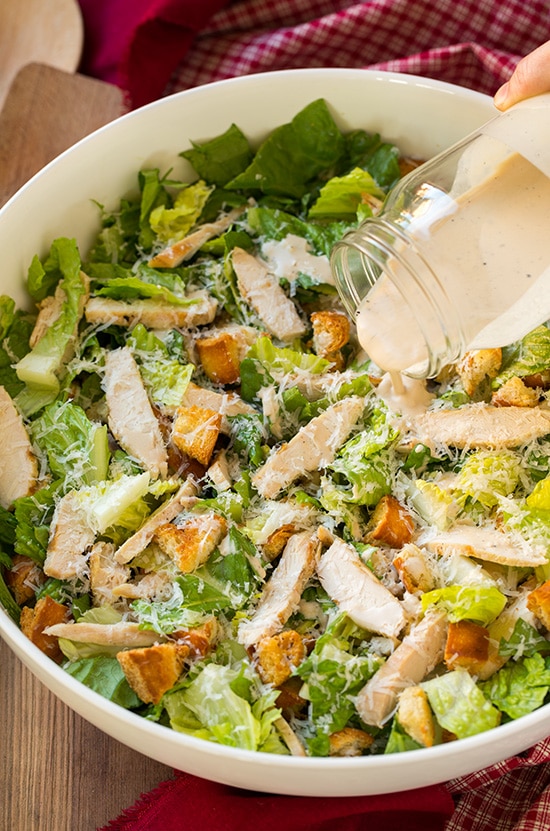 Homemade caesar salad dressing poured on salad