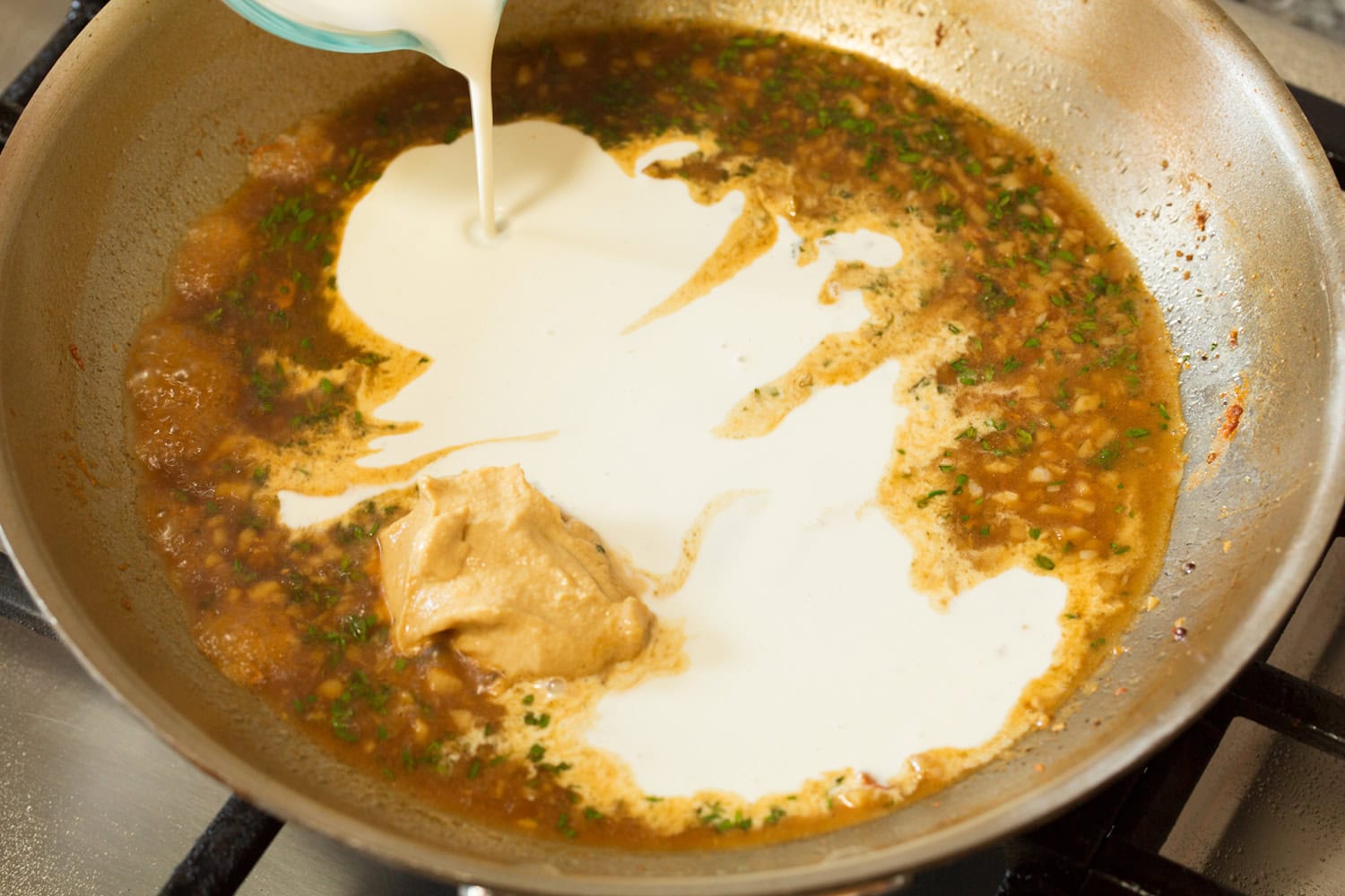 Heavy cream added to broth mixture in skillet.