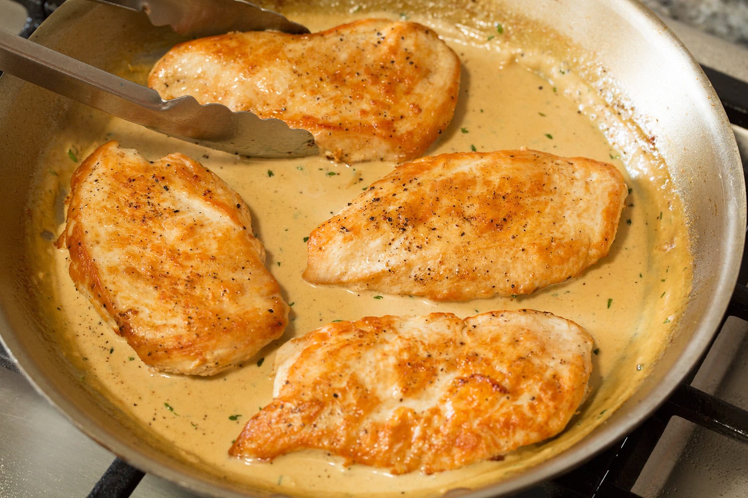 Seared chicken returned to sauce mixture in skillet.