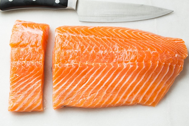 Baked Salmon and Asparagus in Foil Cutting a side of salmon into fillets.