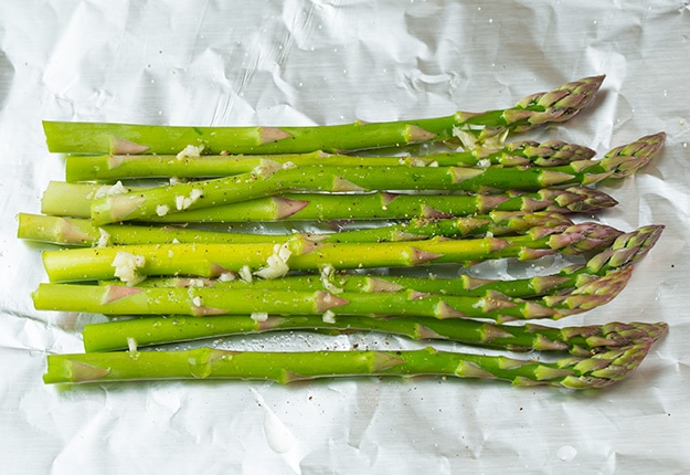 Salmon and Asparagus in foil. Laying asparagus on sheet of foil before topping with salmon.