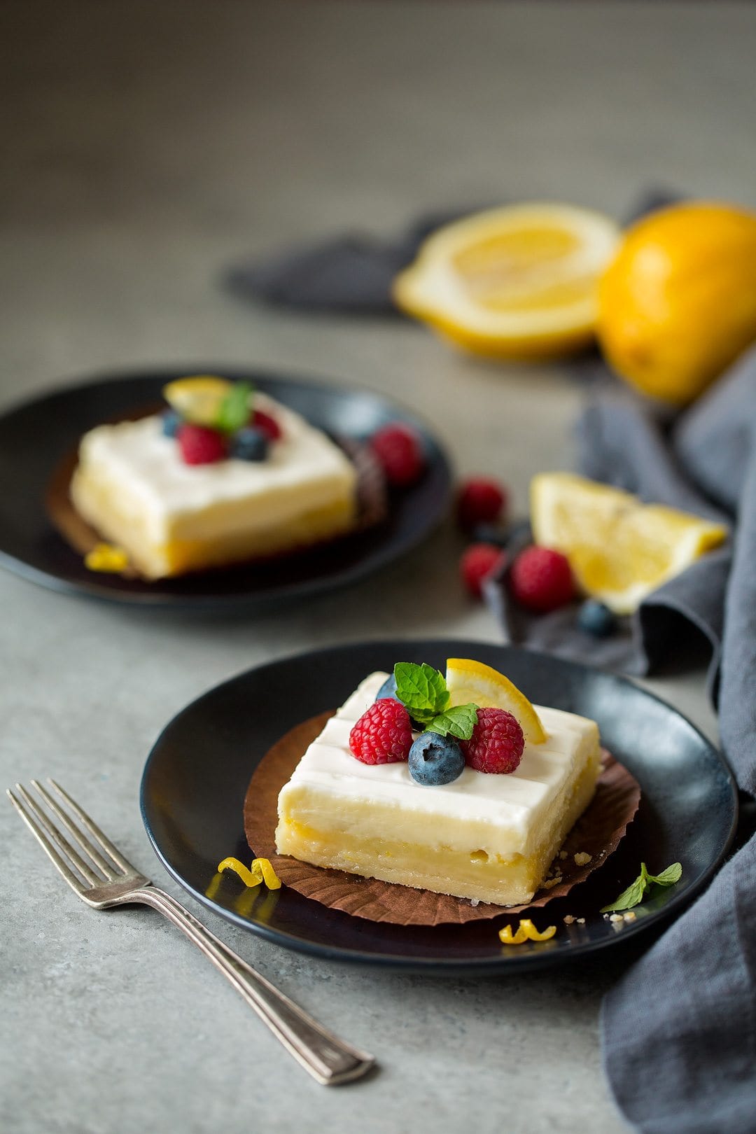 two slices of Lemon Cheesecake Bars on plates 