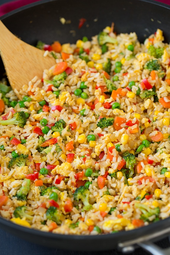 veg fried rice in a skillet with a wooden spoon