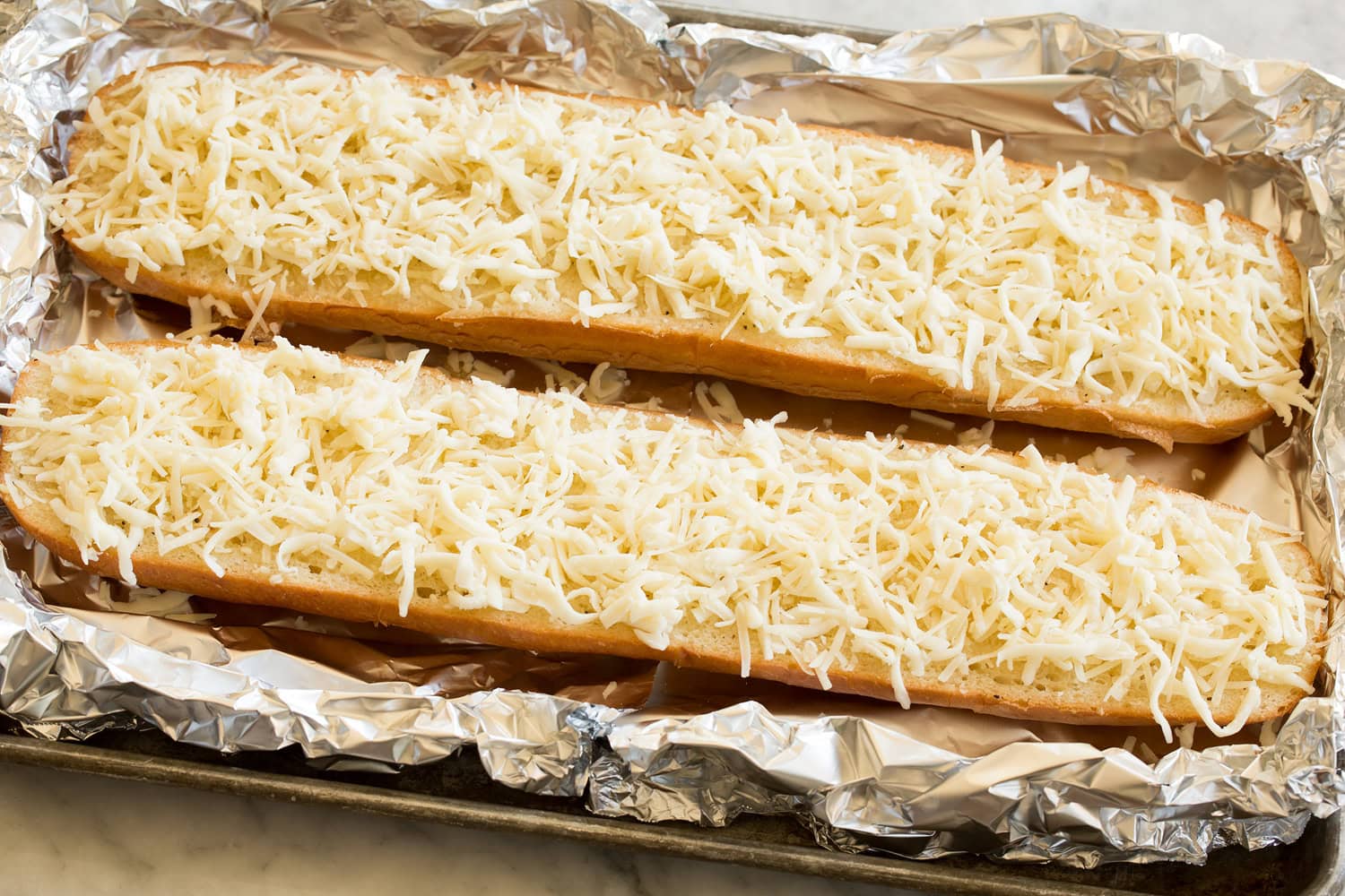 Cheese added to french bread halves.