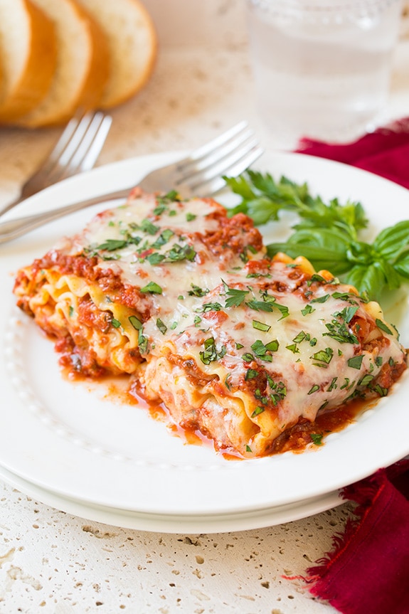 Two Lasagna Roll Ups on a white plate with a fork