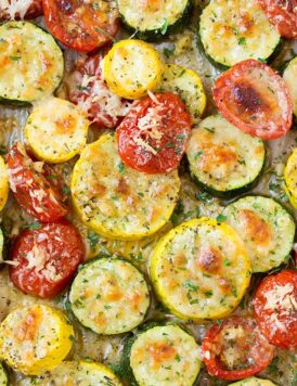 A close up of roasted zucchini and other veg on a roasting pan