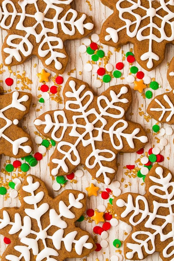 Gingerbread cookies sitting on a white wooden surface.