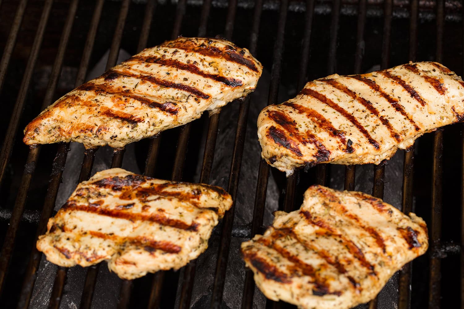 Caprese Chopped Salad Grilled marinated chicken breasts shown with nice char marks on a dark grill.