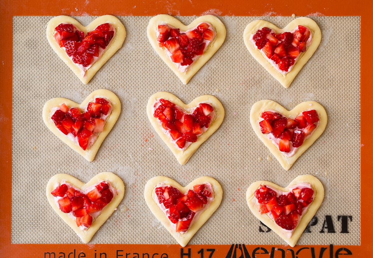 Adding strawberries to breakfast pastries
