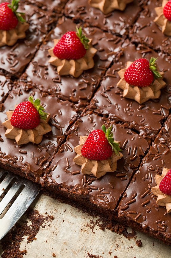 Spatula serving homemade chocolate cake from sheet pan