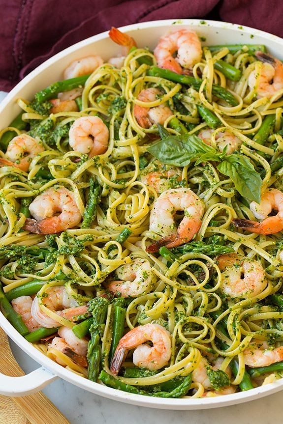 shrimp pesto pasta with asparagus in white serving bowl