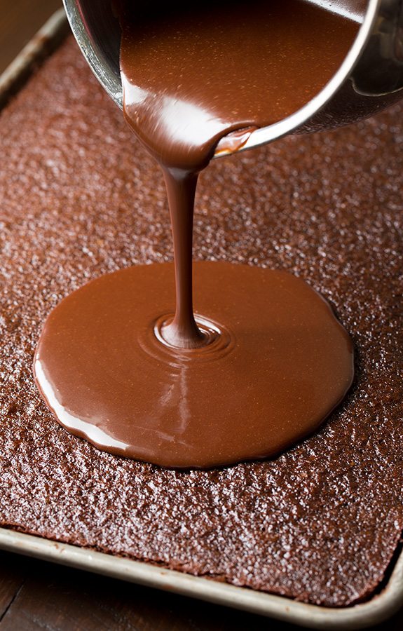 Creamy chocolate topping poured onto Chocolate Sheet Cake 