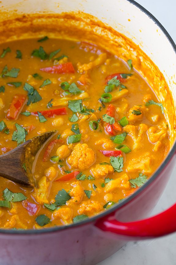 Red vegetable curry in a large red pot after simmering and finished.