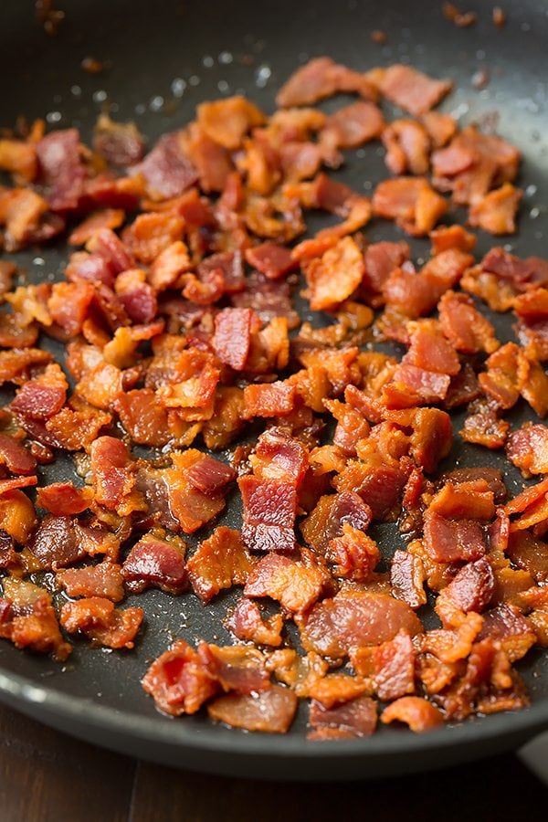 Bacon pieces frying in a pan for making a Broccoli and Cauliflower Salad 