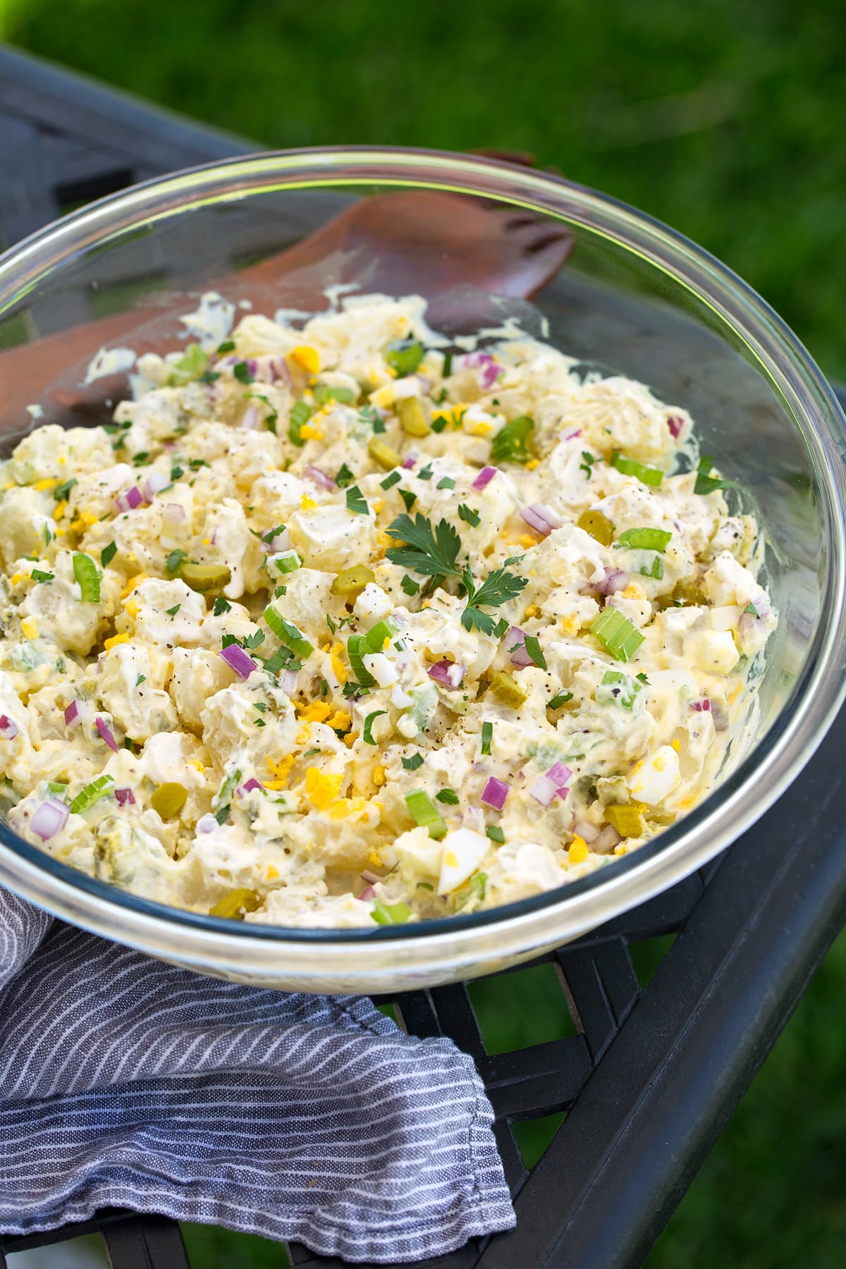 A glass bowl of potato salad on a table