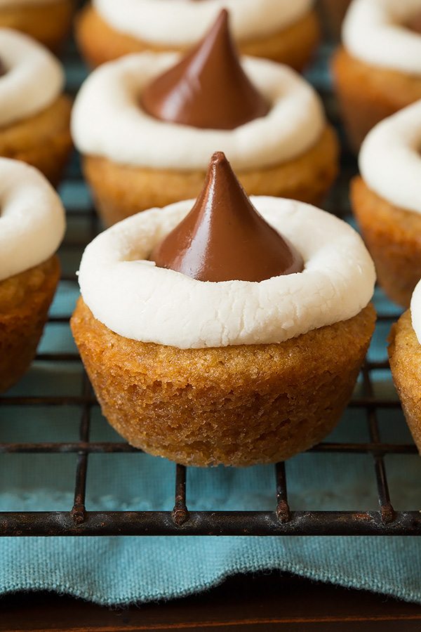 Close up image of s'more cookie cup. Graham cracker cookie base with marshmallow halve in middle and a chocolate hershey's kiss on top.