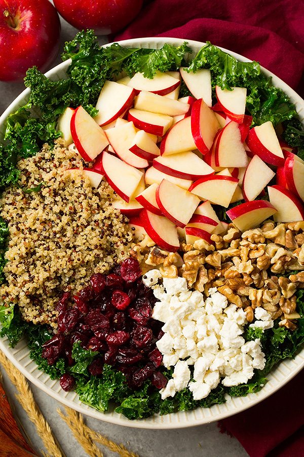 Autumn Kale Apple and Quinoa Salad Kale salad ingredients in a salad bowl before tossing.
