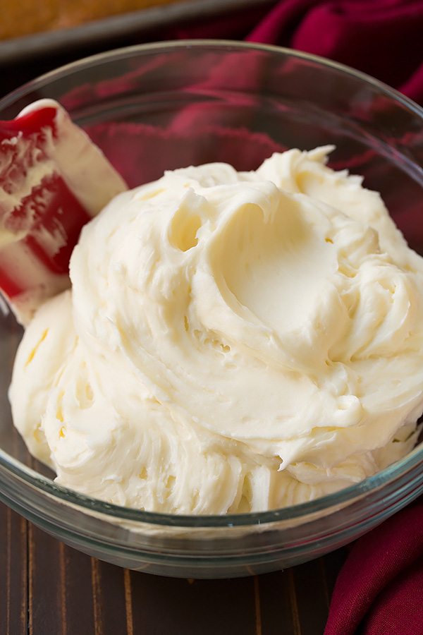 Cream cheese frosting in a glass mixing bowl, for pumpkin cake.