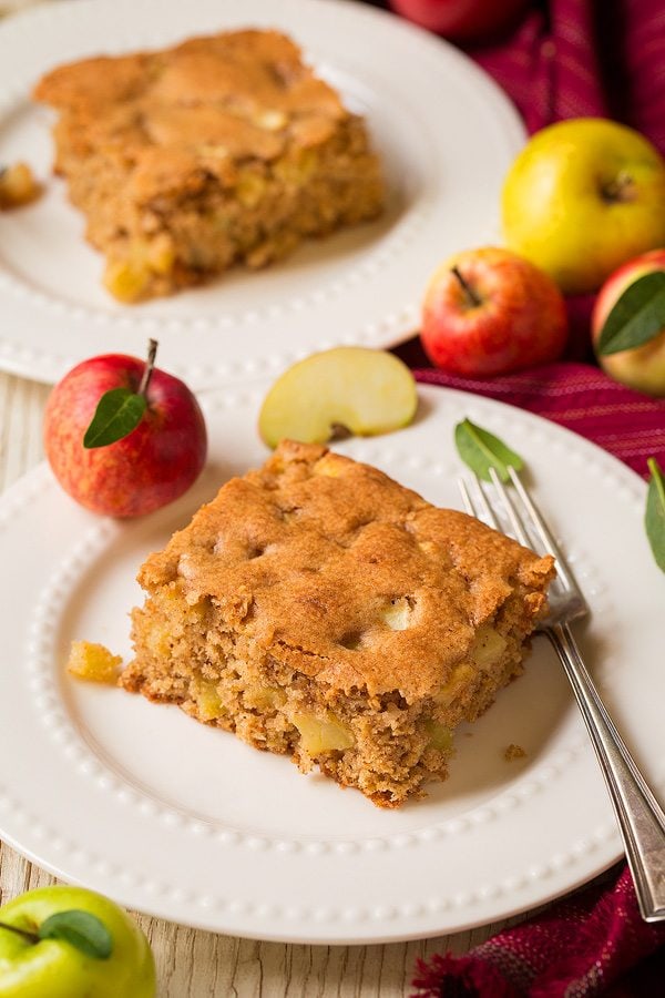 Two slices of apple cake on dessert plates. 