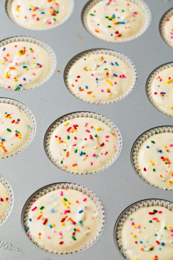 rainbow sprinkle Cheesecake batter in 12 cupcake wells before baking.