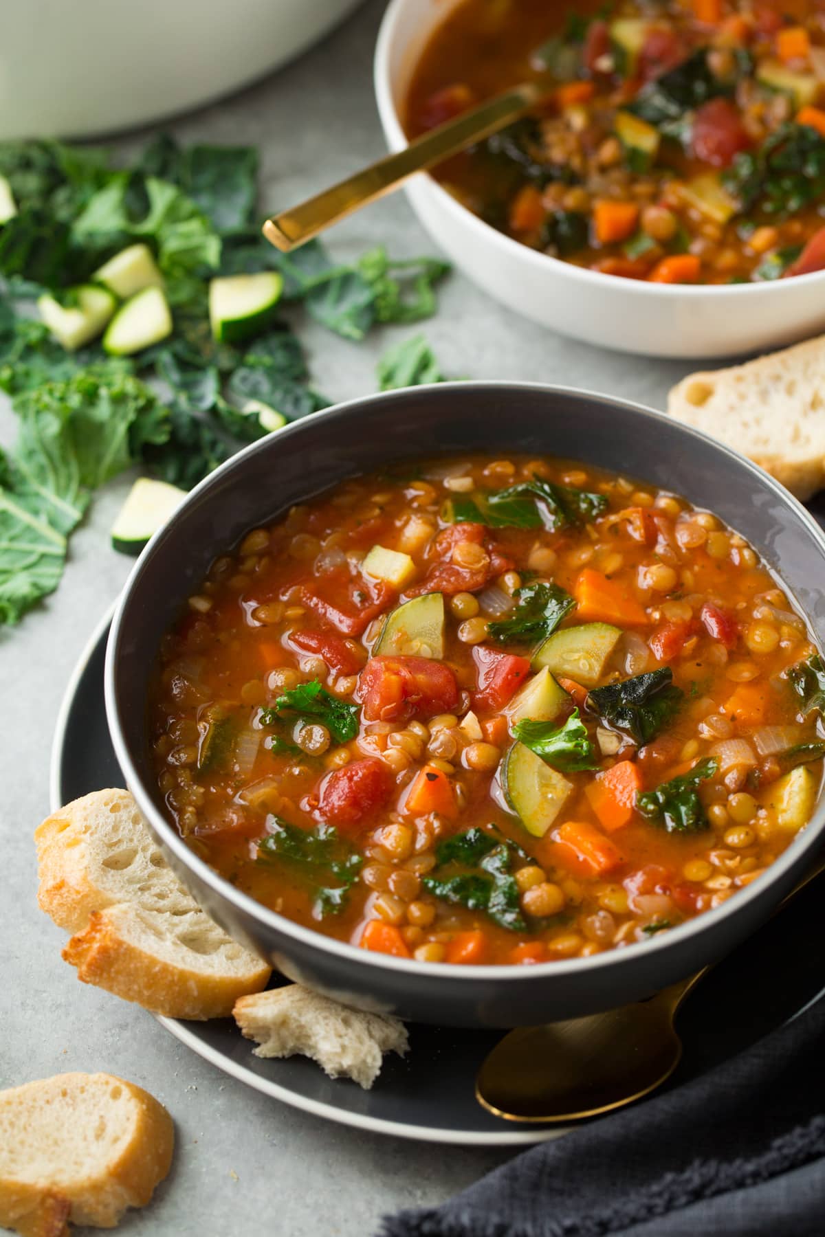 Lentil Soup in a gray bowl with bread on the side