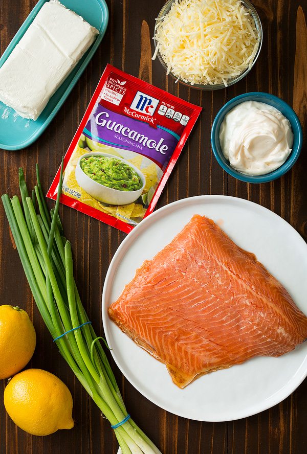 Ingredients needed for smoked salmon dip shown here. Includes cream cheese, mayonnaise, greek yogurt, white cheddar, green onions, lemons, seasoning, smoked salmon.