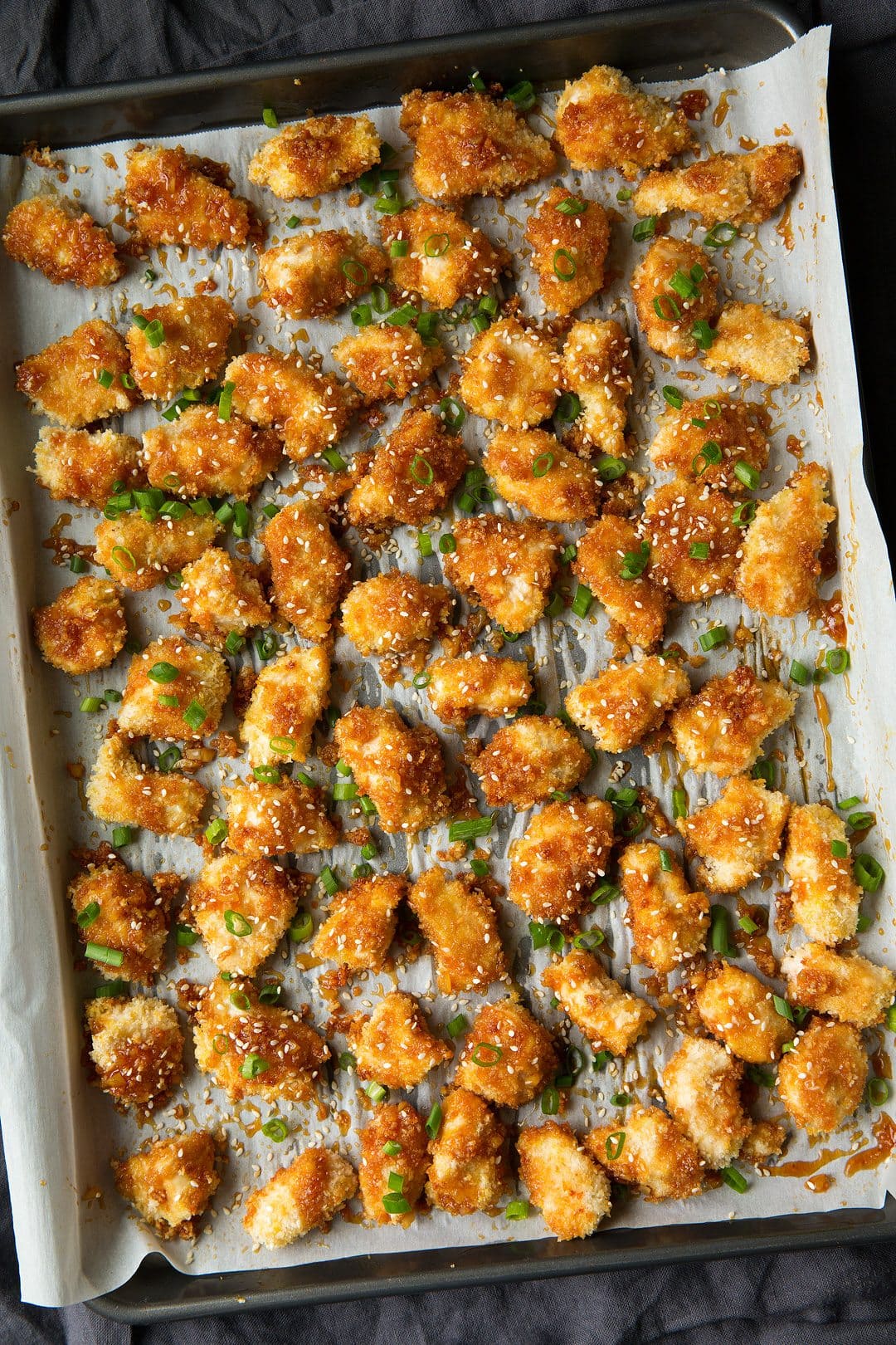 Honey Garlic Chicken on a parchment line baking sheet after baking.