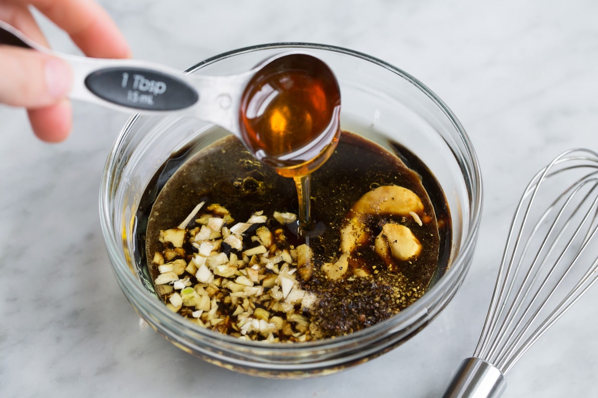 Showing how to make a kebab marinade, whisking liquid ingredients in a glass mixing bowl.
